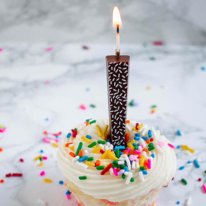 Edible Dark Chocolate Candle with white sprinkles on vanilla cupcake with sprinkles | Let Them Eat Candles