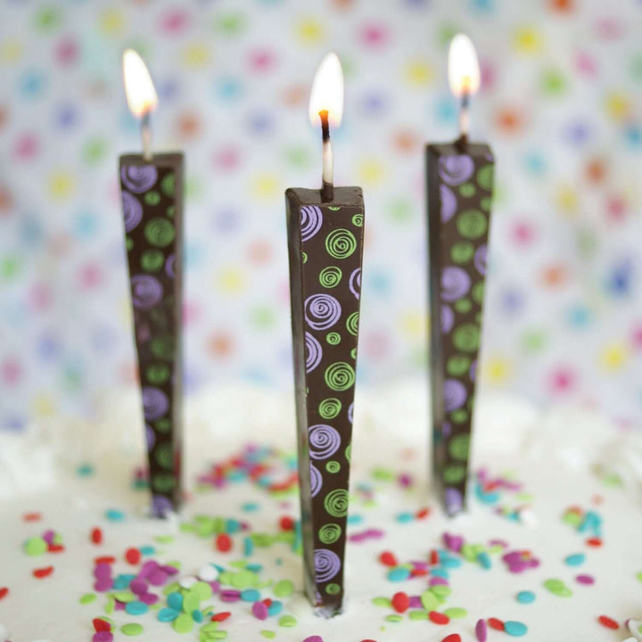 Edible Dark Chocolate Candles with purple/green spirals on cake with sprinkles | Let Them Eat Candles