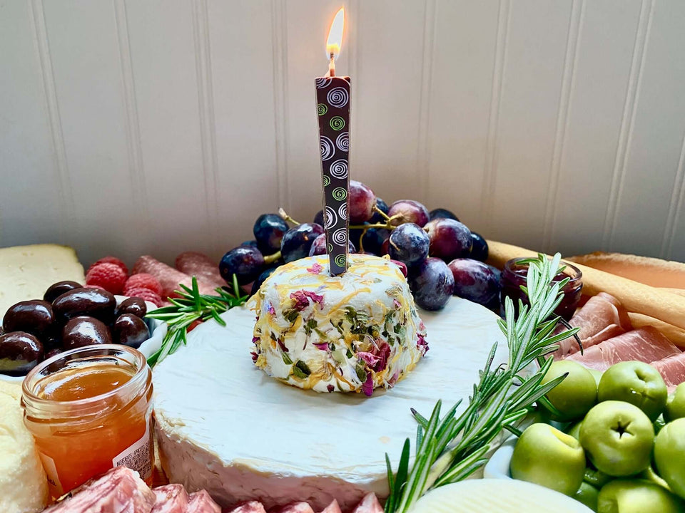 Edible Dark Chocolate Candle with purple/green spirals on cheese with fruit | Let Them Eat Candles